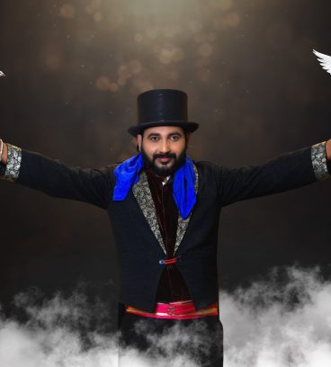 Magician vasanth performing magic with two pigeons in two hands